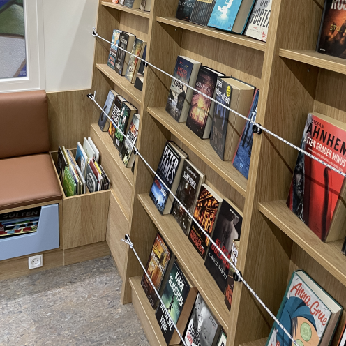 Udsnit af bøger på hylder i en biblioteksvogn