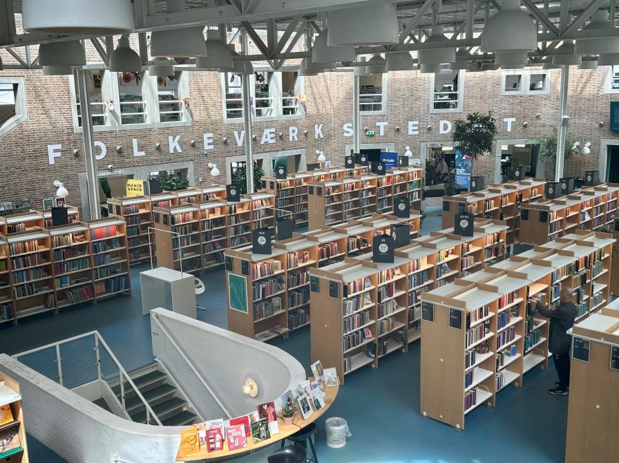 Udsigt oppe fra over Hovedbibliotekets rum. I baggrunden ses "FOLKEVÆRKSTEDET" på væggen.