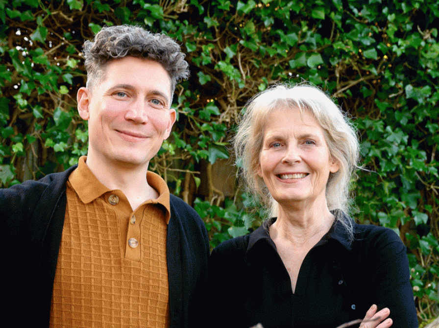 Psykolog Anne Knudsen og læge, sociolog og ph.d. Søren Valgreen Knudsen står foran en væg, der er bevokset med "arkitektens trøst".